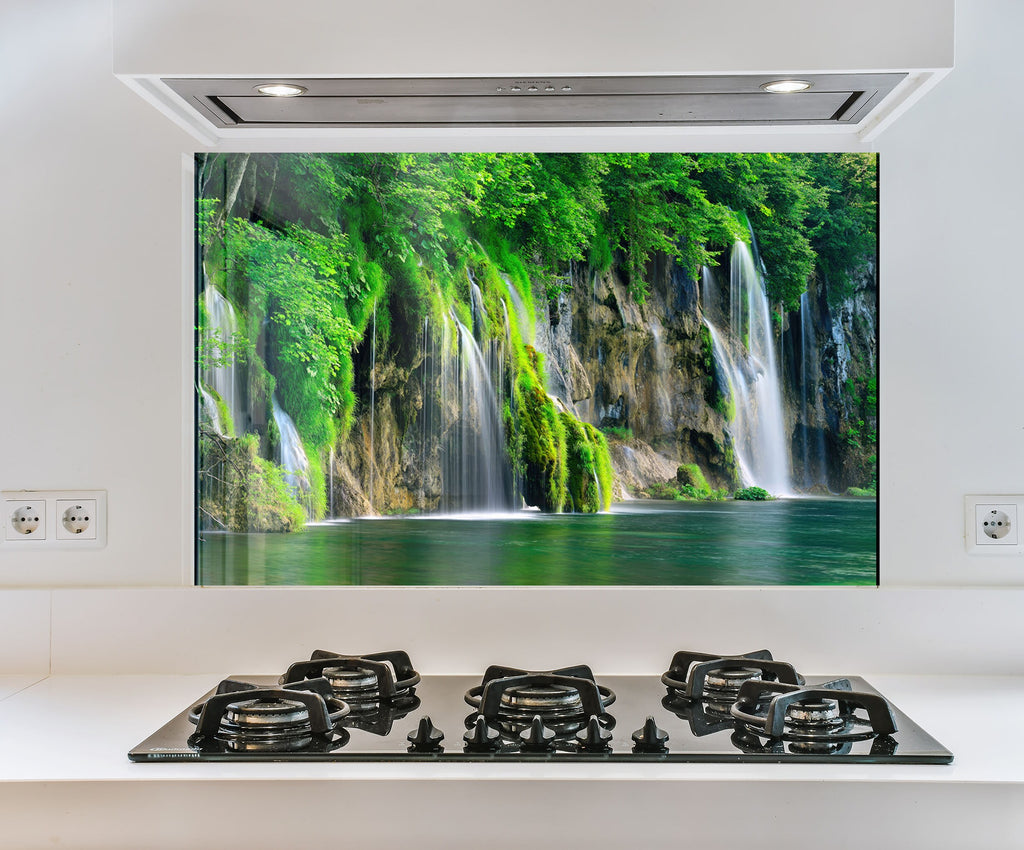 a picture of a waterfall in a green forest