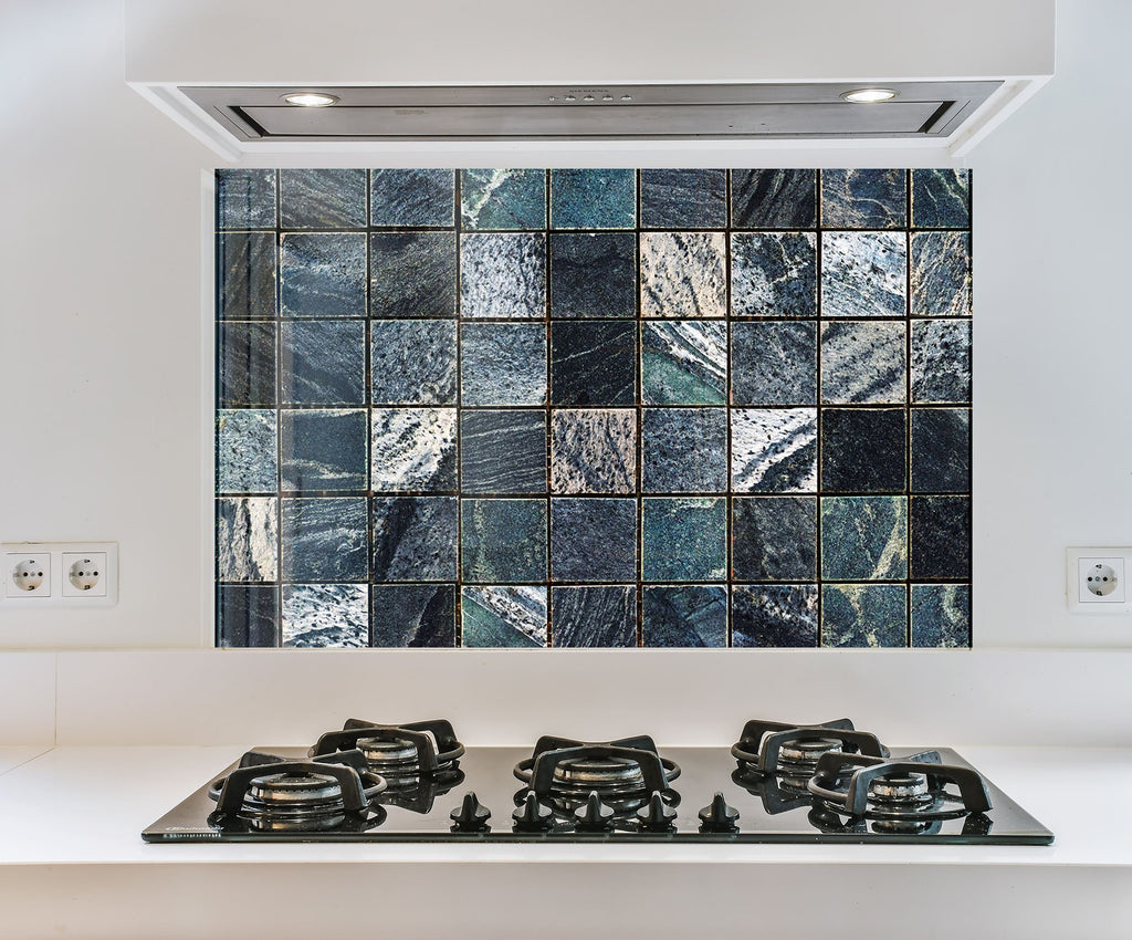 a stove top sitting under a tiled wall