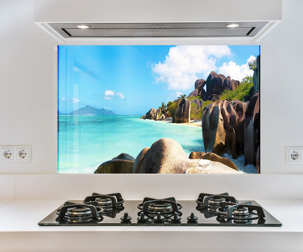 a picture of a beach is on the wall above the stove