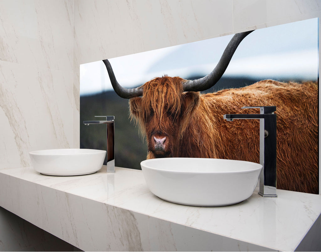 a picture of a bull is on the wall behind a bathroom sink